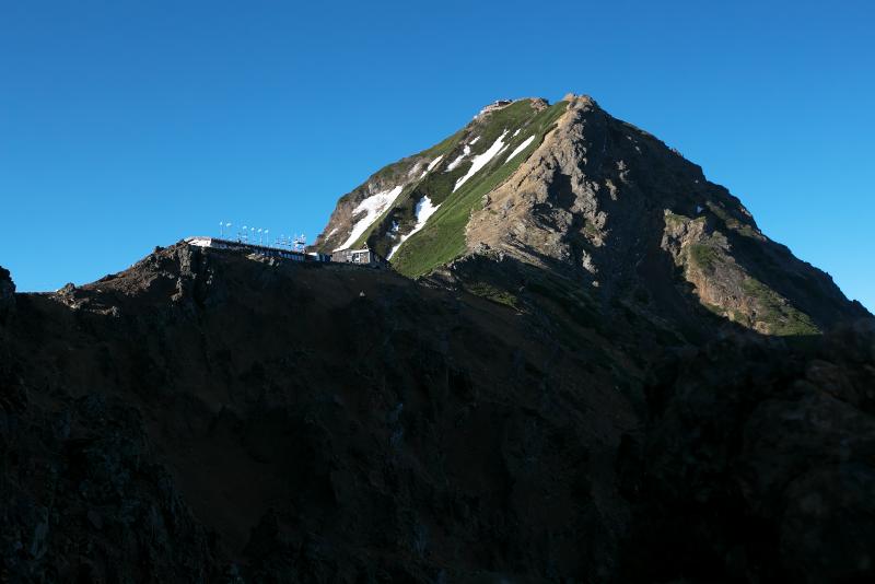 朝日に輝く赤岳と、山頂の肩に立つ赤岳展望荘
